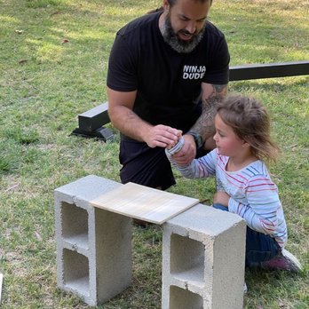Ninja Dude Parties - Brandon showing my daughter how to snap the board in half - Party & Event Planning Near Me Ninja Dude Parties - Brandon showing my daughter how to snap the board in half - Party & Event Planning Near Me