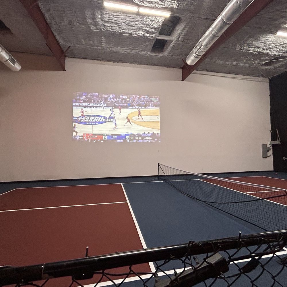 Indoor pickleball area with TV