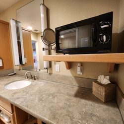 Cambria Shores Inn - Cambria Shores Inn - Room 22, bathroom sink area has microwave on shelf, and fridge under the counter