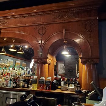 Henry's - The wood piece behind the bar is from an old saloon in the Wild, Wild West! - New American Near Me - Wilmington, North Carolina