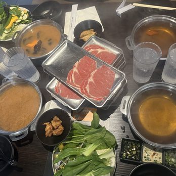 Shabuya - Table set-up for 4.  Two House broth and 2 spicy miso.  Veggies and first order of meats. Haven't got the seafood and noodles yet. - Hot Pot Near Me - Honolulu, Hawaii