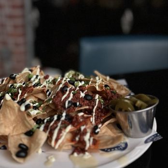 Growlers - Beef Chili Nachos (corn tortilla chips, house made chili, white cheddar cheese sauce, black beans, jalapeños, lime crema) - Sports Bars Near Me - Chula Vista, California Growlers - Beef Chili Nachos (corn tortilla chips, house made chili, white cheddar cheese sauce, black beans, jalapeños, lime crema) - Sports Bars Near Me - Chula Vista, California