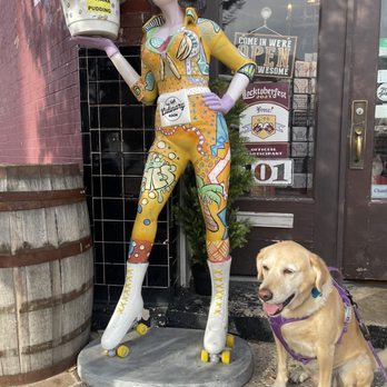 The Culinary Room - My dog, Rainey, posing with Barbara banana in front of the culinary room - Desserts Near Me - Lockhart, Texas