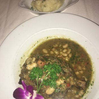 Tavira Restaurant - Pernil de Porco a Madeirense Braised Pork Shank (Osso Bucco Style) in Madeira wine sauce served with fresh cilantro and white beans - Mediterranean Near Me - Chevy Chase, Maryland Tavira Restaurant - Pernil de Porco a Madeirense Braised Pork Shank (Osso Bucco Style) in Madeira wine sauce served with fresh cilantro and white beans - Mediterranean Near Me - Chevy Chase, Maryland