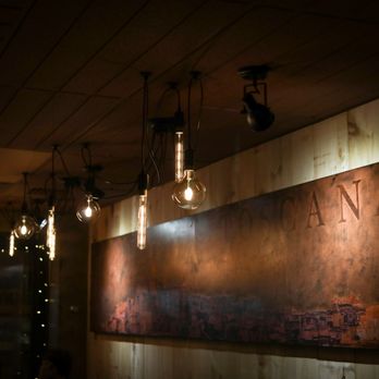 Luciano Trattoria - a wall with hanging light bulbs - Italian Near Me - Montreal, Quebec