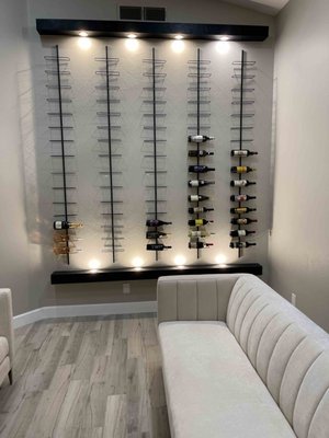 Custom Wine Wall - Our team recently completed a stunning custom wine wall, designed and built from scratch to perfectly suit our client's vision. Our electrical services were also performed, including custom lighting and wiring for the wall's temperature control system. The end result is a beautiful and functional addition to our client's home that is sure to impress guests and provide a convenient and stylish storage solution for their wine collection.