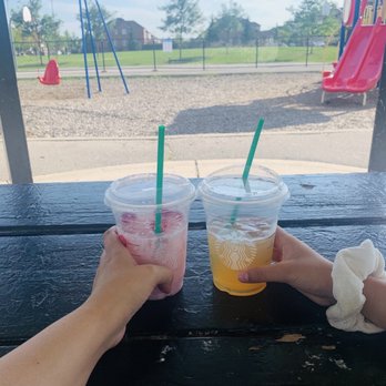 Starbucks - two people holding drinks at a picnic table - Coffee & Tea Near Me - Milton, Ontario Starbucks - two people holding drinks at a picnic table - Coffee & Tea Near Me - Milton, Ontario