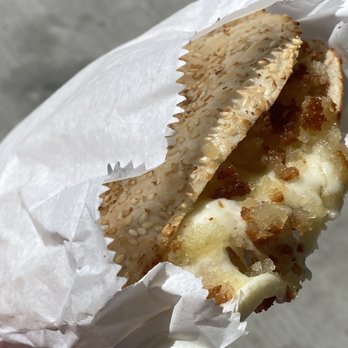 Cedar Sweets - a hand holding a sandwich wrapped in paper - Bakeries Near Me - Edmonton, Alberta Cedar Sweets - a hand holding a sandwich wrapped in paper - Bakeries Near Me - Edmonton, Alberta