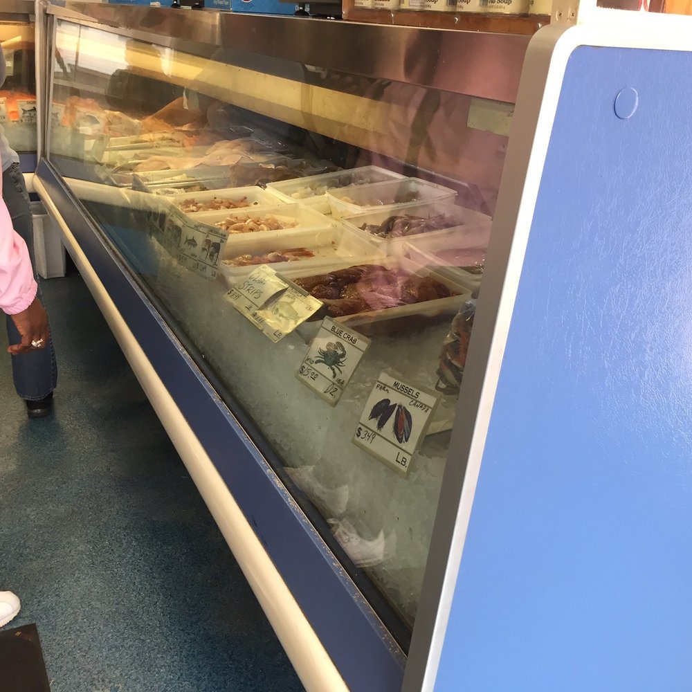 Klein Seafood - a woman standing in front of a display case - Seafood Markets Near Me - Akron, Ohio