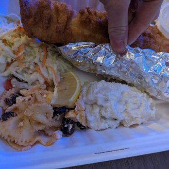Potters Field - a person putting a piece of fish in a foil wrap - Irish Near Me - Buffalo, New York