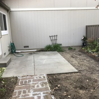 Abbott Concrete - a backyard with a brick walkway - General Contractors Near Me