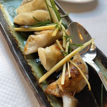 Le Colonial - Sui Cao Chien - Pan Seared Dumplings - Dumplings are served on a rectangular ceramic plate, garnished with julienned ginger and chopped green onion, with a soy-based dipping sauce. - Vietnamese Near Me - Chicago, Illinois