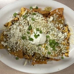 Great Chilaquiles with scrambled eggs and chorizo with sour cream and diced green onions on top.