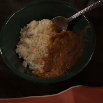 Ayayay - Beans & Rice side - A green bowl contains white rice and a portion of beans in sauce, with a spoon resting inside the bowl. - Mexican Near Me - Chicago, Illinois