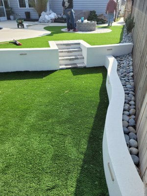 Outdoor Living Space - This project started with a complete regrade of the yard to construct a retaining wall--complete with smokeless fire pit and artificial turf putting green! It is topped off with stunning landscape lighting to set it all off! Outdoor Living Space - This project started with a complete regrade of the yard to construct a retaining wall--complete with smokeless fire pit and artificial turf putting green! It is topped off with stunning landscape lighting to set it all off!