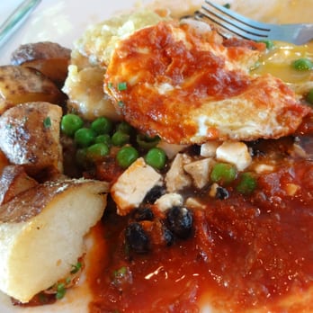 Eat. - Huevos Montulenos(under attack...peas, black beans, feta, and bananas underneath the egg and christmas sauce) - New American Near Me - Las Vegas, Nevada