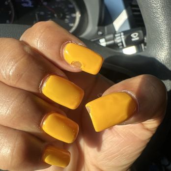 Master Nails - Laurel - Nails needed to be redone twice in two days - The image depicts a person's hand with yellow nail polish, which is chipped and damaged on several nails. The hand is positioned inside a vehicle, with the dashboard, steering wheel, and part of the car's interior visible in the background. The lighting suggests it is daytime. - Nail Salons Near Me - Laurel, Maryland