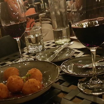 Vin 25 - a glass of wine and a plate of food on a table - New American Near Me - Roswell, Georgia Vin 25 - a glass of wine and a plate of food on a table - New American Near Me - Roswell, Georgia