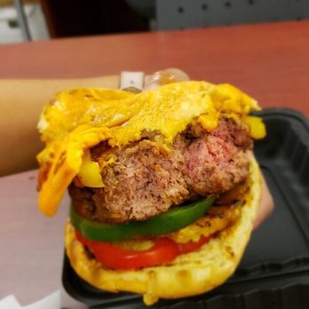 Jamaica Vibes Restaurant - a hand holding a hamburger - Caribbean Near Me - Dartmouth, Nova Scotia