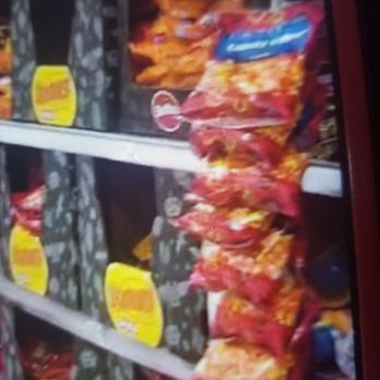 H-E-B - Produce - Grocery store shelves display snack bags, including chips and other packaged foods, with some items in yellow and red packaging. - Drugstores Near Me - Lakeway, Texas