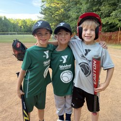 Three sponsor logos, three baseball caps, and one kid who clearly forgot "Y" stands for something other than "youth batting helmet fashion"
