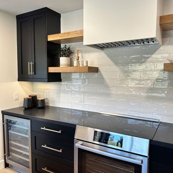 Moretti Construction - a kitchen with black cabinets and stainless steel appliances - General Contractors Near Me - San Marcos, California Moretti Construction - a kitchen with black cabinets and stainless steel appliances - General Contractors Near Me - San Marcos, California