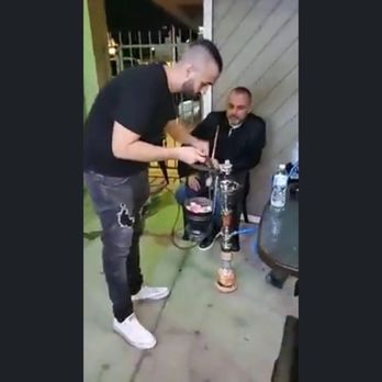 Royal hookah lounge - a man holding a hookah while another man looks on - Hookah Bars Near Me - Los Angeles, California Royal hookah lounge - a man holding a hookah while another man looks on - Hookah Bars Near Me - Los Angeles, California