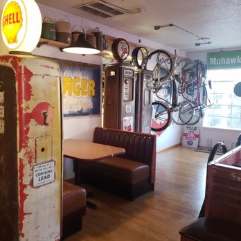 Hausammann Brewhaus - an old gas pump in a restaurant - Interior of a restaurant featuring vintage gas station memorabilia, bicycles mounted on the wall, and antique payphones, creating a nostalgic atmosphere. - Beer Bar Near Me - Albuquerque, New Mexico