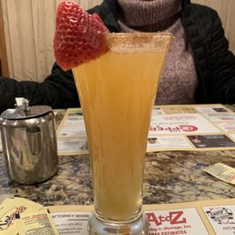 Apple cider mimosa with cinnamon sugar rim and fresh strawberry.
