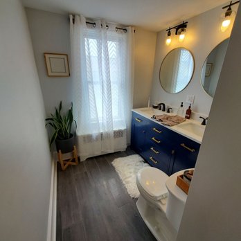 Precise Home Services - a bathroom with a toilet, sink, and mirror - General Contractors Near Me