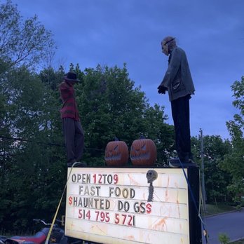 Haunted Dogs - two men standing on top of a sign - Hot Dogs Near Me