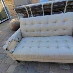 Leather sofa with right armrest torn and padding torn out. Leather sofa with right armrest torn and padding torn out.
