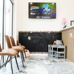 Elite Pediatric Dentistry & Orthodontics - Waiting area consisting of various toys and a giant chalkboard to keep children entertained!