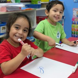 World Of Learning Academy - Two young learners practice their writing skills in our classroom writing area, building early literacy skills through hands-on learning