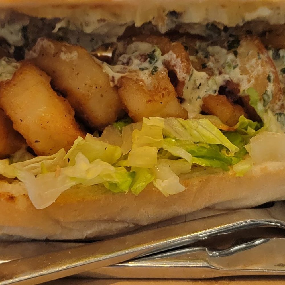 La Pescaria Fishmonger & Kitchen - a hand holding a sandwich - Seafood Near Me - Las Vegas, Nevada La Pescaria Fishmonger & Kitchen - a hand holding a sandwich - Seafood Near Me - Las Vegas, Nevada