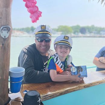 Put-in-Bay Floating Tiki - ows a man and a young boy sitting on a boat - Boat Tours Near Me - Put-in-bay, Ohio Put-in-Bay Floating Tiki - ows a man and a young boy sitting on a boat - Boat Tours Near Me - Put-in-bay, Ohio