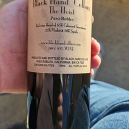a hand holding a bottle of wine