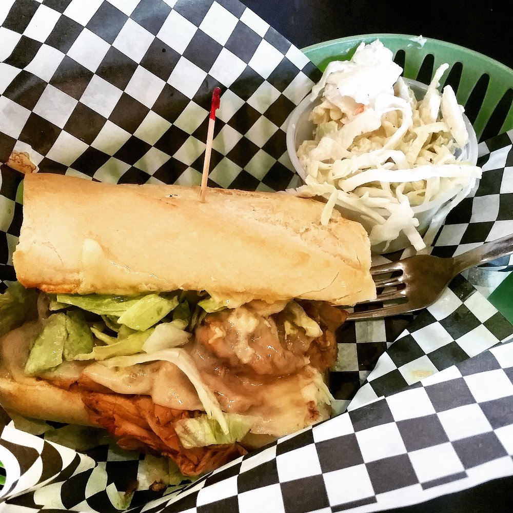 Movable Feast - This sandwich isn't photogenic but it's amazing - Jerked Pork with swiss, lettuce, jerk mayo, on a fresh baguette! Get this! - Specialty Food Near Me - Indianapolis, Indiana