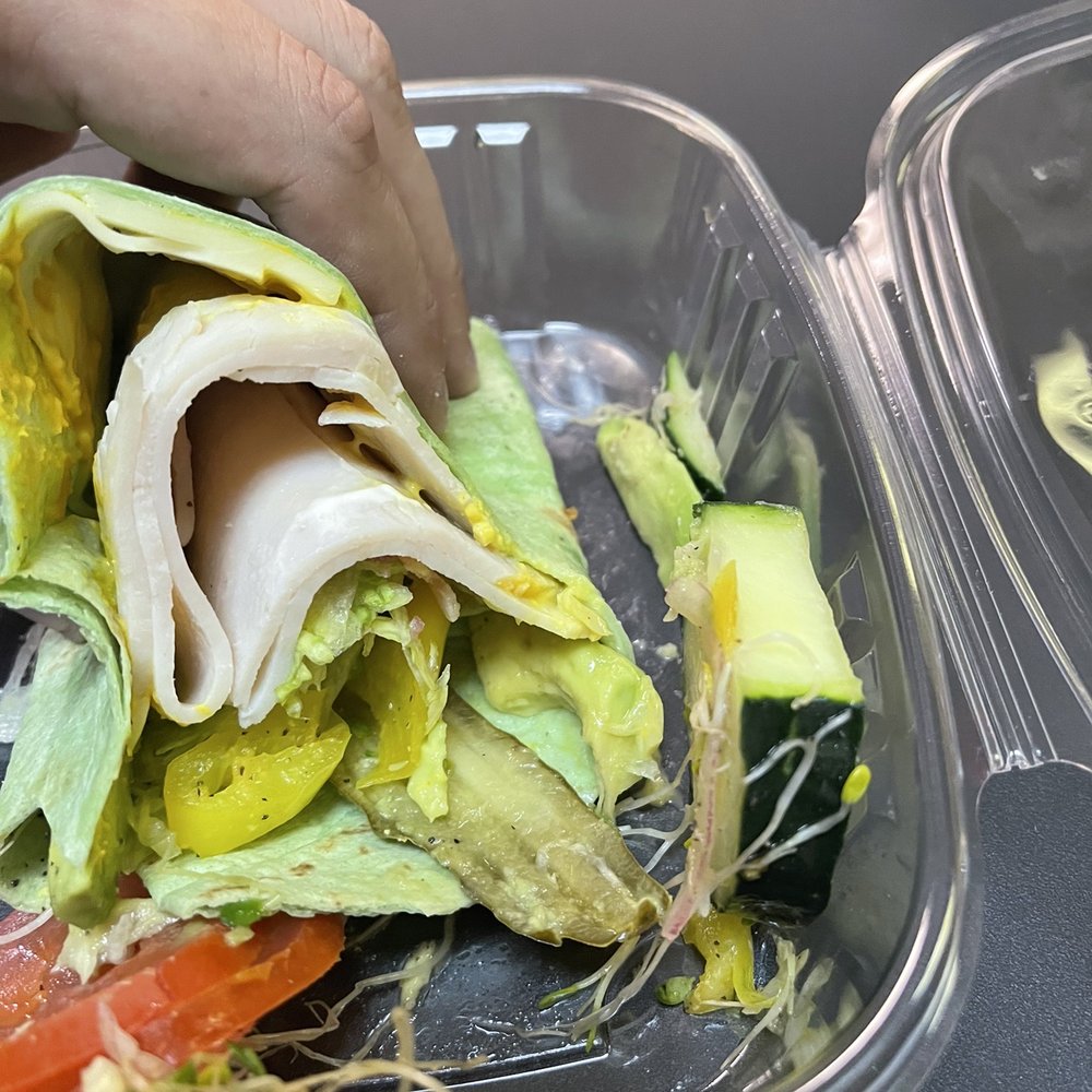 a person putting a sandwich in a container