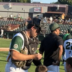 Tri-City Valleycats - Player signing autographs for young fans on the field.