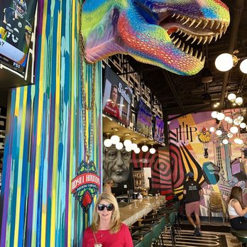 Proper Restaurant & Bar - a woman standing in front of a colorful dinosaur - Beer Bar Near Me - Inlet Beach, Florida Proper Restaurant & Bar - a woman standing in front of a colorful dinosaur - Beer Bar Near Me - Inlet Beach, Florida