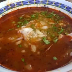Menudo topped with onion, cilantro and oregano