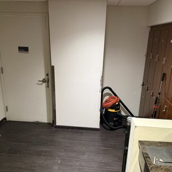 Complete Playground - Cleaning supplies, vacuum, and assorted junk laying out in the taped-up men's room, even though a storage door is directly next to them. - Playgrounds Near Me - New York, New York