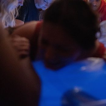 BWS Doulas - Birth client pushing with partner, midwife and doula supporting nearby - Childbirth Education Near Me