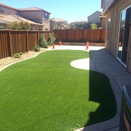 Artificial turf with stamped concrete. Cones are covering pergola brackets.