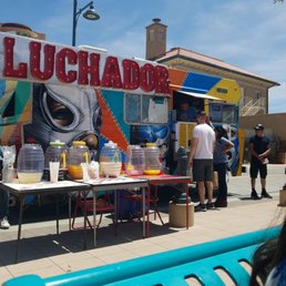 people standing in front of a food stand people standing in front of a food stand