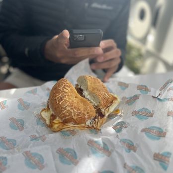 Siegel's Bagelmania - a man taking a picture of a sandwich - Delis Near Me - Las Vegas, Nevada Siegel's Bagelmania - a man taking a picture of a sandwich - Delis Near Me - Las Vegas, Nevada