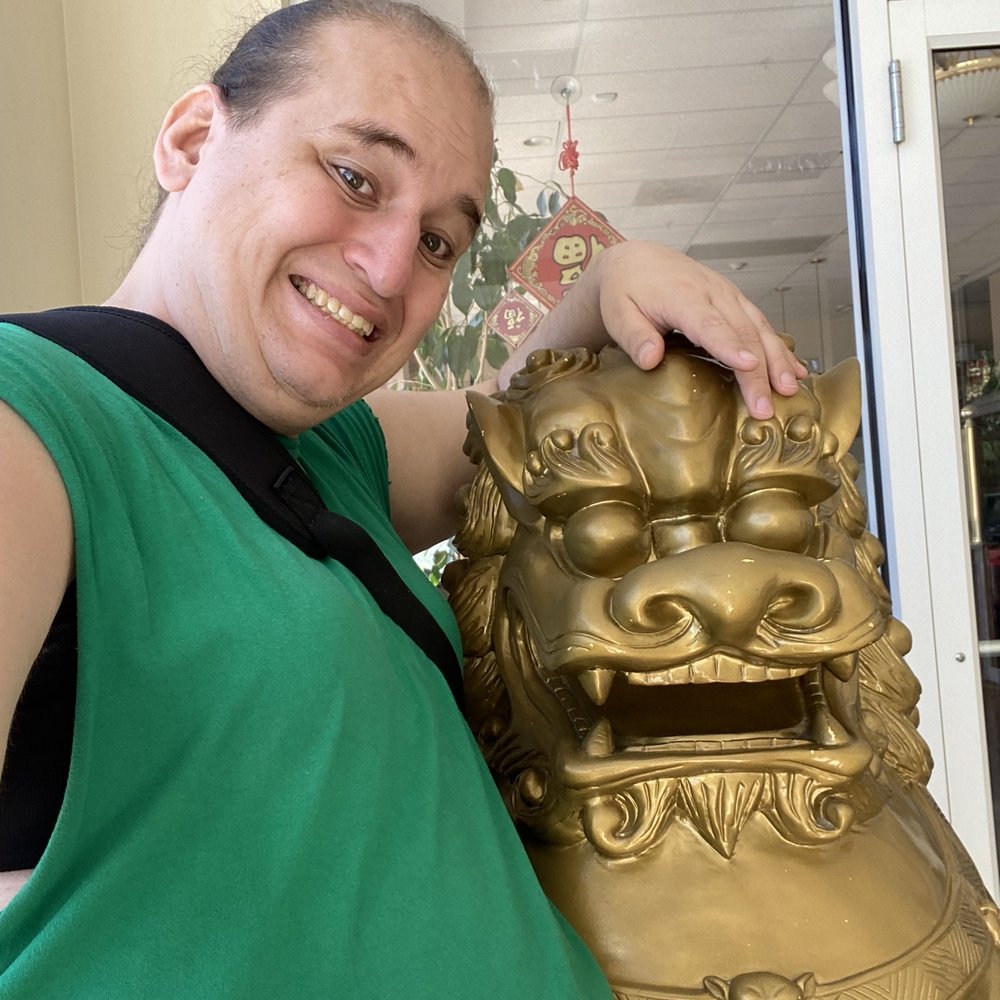 a man posing with a golden lion statue a man posing with a golden lion statue