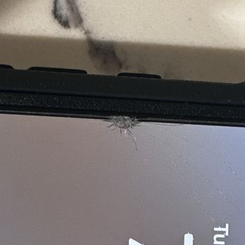 T-Mobile - Cracked my screen protector - A device with a damaged screen protector shows a spider web crack near the top edge, with a small spider visible on the protector. - Electronics Near Me - Poway, California