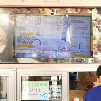 El Street Taco - a man standing in front of a menu - Mexican Near Me - Anaheim, California El Street Taco - a man standing in front of a menu - Mexican Near Me - Anaheim, California